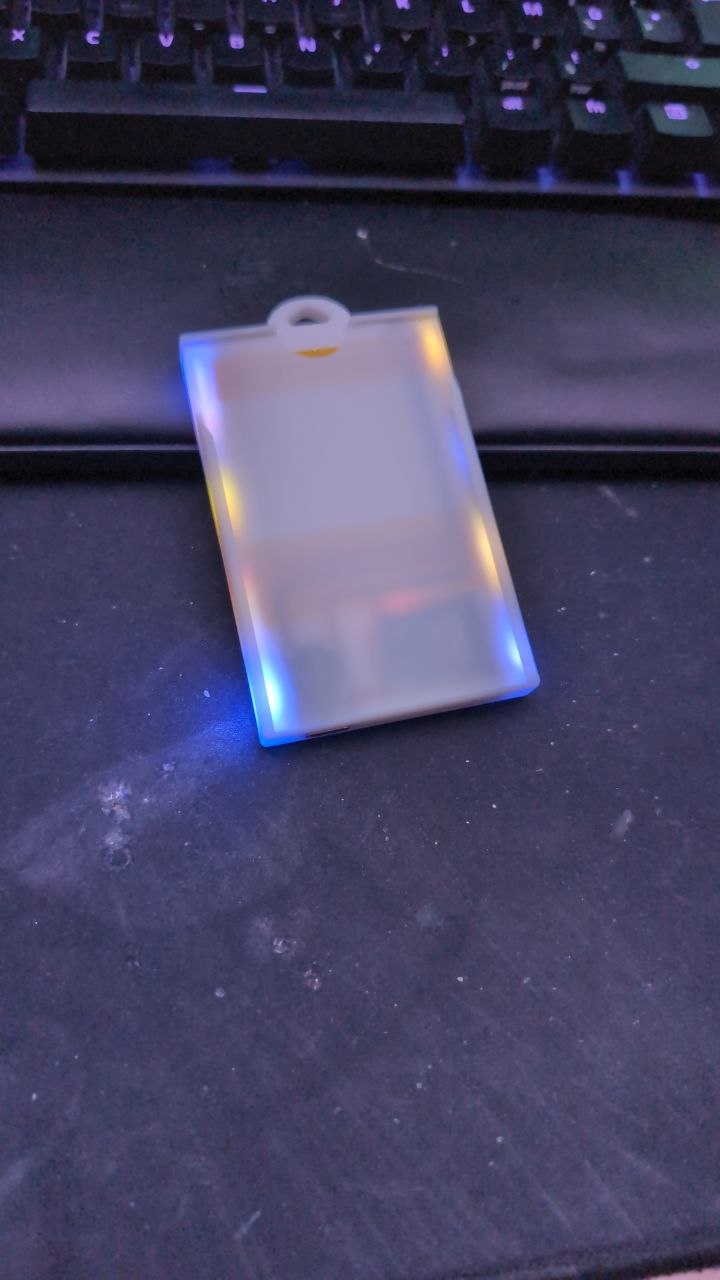 Un porte-badge terminé, allumé, posé sur un tapis de bureau